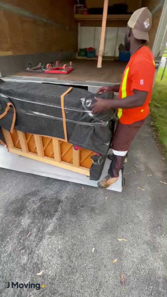 A J Moving+ crew wrapping, carrying and setting down an upright piano